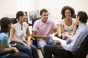 Man giving lecture to four people in computer room