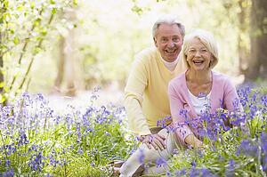 Couple sitting outdoors with flowers smiling