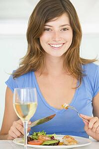 Young Woman Enjoying meal, mealtime With A Glass Of Wine