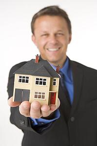 Businessman Holding Small House 