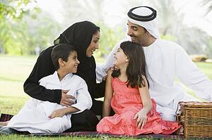 Family outdoors in park having a picnic and smiling (selective focus)