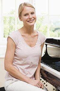 Woman sitting at piano and smiling