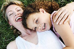 Mother and daughter outdoors smiling
