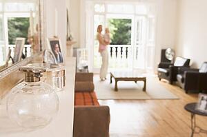 Woman standing in living room holding baby