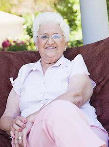 Senior woman sitting outdoors on a chair