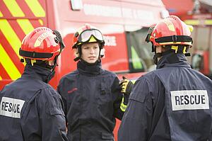 Three rescue workers talking by rescue vehicle (selective focus)