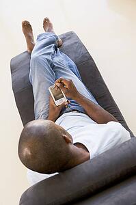Man sitting in chair using personal digital assistant