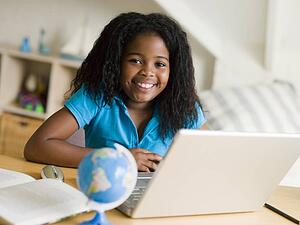 Young Girl Doing Her Homework On A Laptop