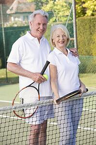 Couple playing tennis and smiling