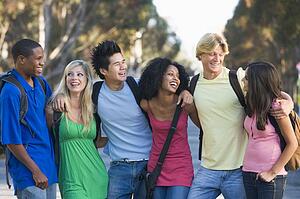 Six people outdoors standing arm in arm together (selective focus)