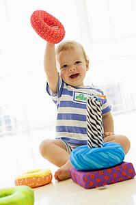 Baby indoors playing with soft toy