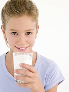 Young girl with glass of milk smiling
