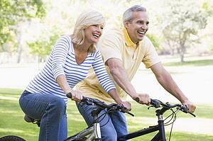 Couple on bikes outdoors smiling