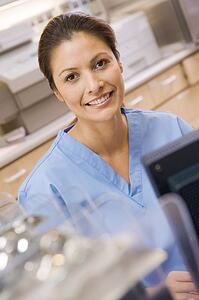 A Nurse Sitting At A Computer At The Reception Area Of A Hospital