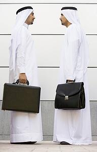 Two businessmen standing outdoors with briefcases
