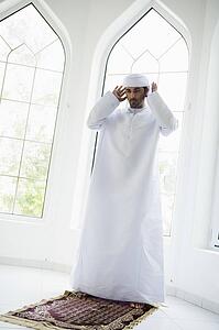 Man in turban standing on mat (high key)