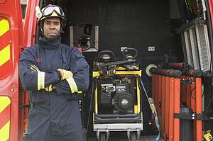 Rescue worker standing by open back door of rescue vehicle