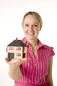 Businesswoman Holding Small House 