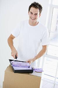 Man painting room in new home smiling