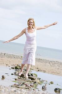 Woman walking on beach path smiling