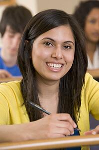Student in class taking notes (selective focus)