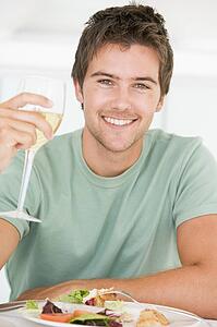 Young Man Enjoying meal, mealtime With A Glass Of Wine
