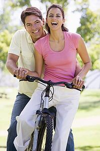 Couple on a bike outdoors smiling