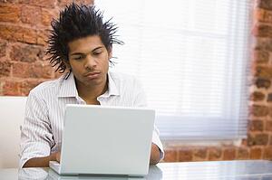 Businessman in office typing on laptop