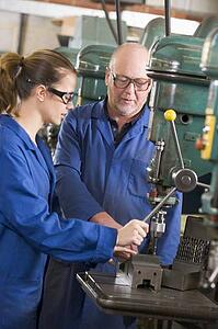 Two machinists working on machine