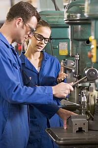 Two machinists working on machine