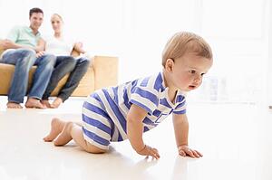 Couple in living room with baby smiling