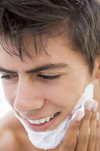 Man putting on shaving cream smiling