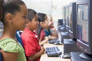 Four children at computer terminals (depth of focus/high key)