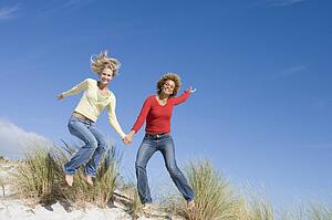 Young woman jumping on a sand hill