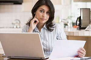 Woman in kitchen with laptop