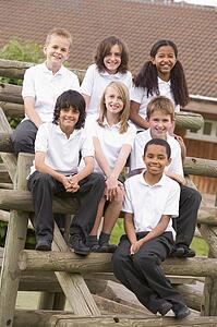 Seven students sitting on wooden structure outdoors