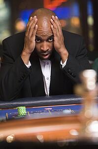 Man in casino playing roulette and losing (selective focus)