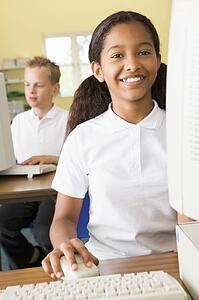 Student at computer terminal with student in background (selective focus)