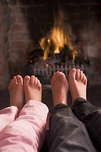 Children's feet warming at a fireplace