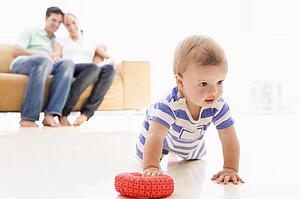 Couple in living room with baby smiling