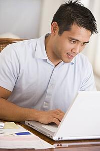 Man in dining room using laptop