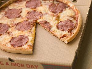 Pepperoni Pizza in a Take Away Box with a Slice Taken