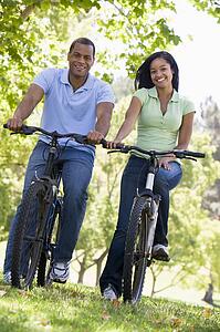 Couple on bikes outdoors smiling