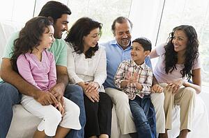 Family sitting in living room smiling (high key)