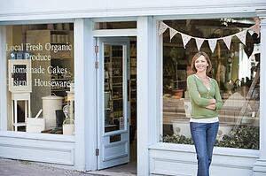 Woman standing in front of organic food store smiling
