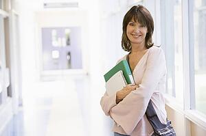 Woman standing in corridor with books (high key)
