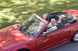 Couple in convertible car smiling