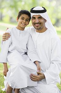 Man and young boy outdoors in a park smiling (selective focus)