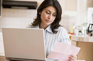 Woman in kitchen with laptop