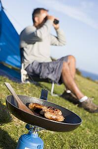 Man camping outdoors and cooking